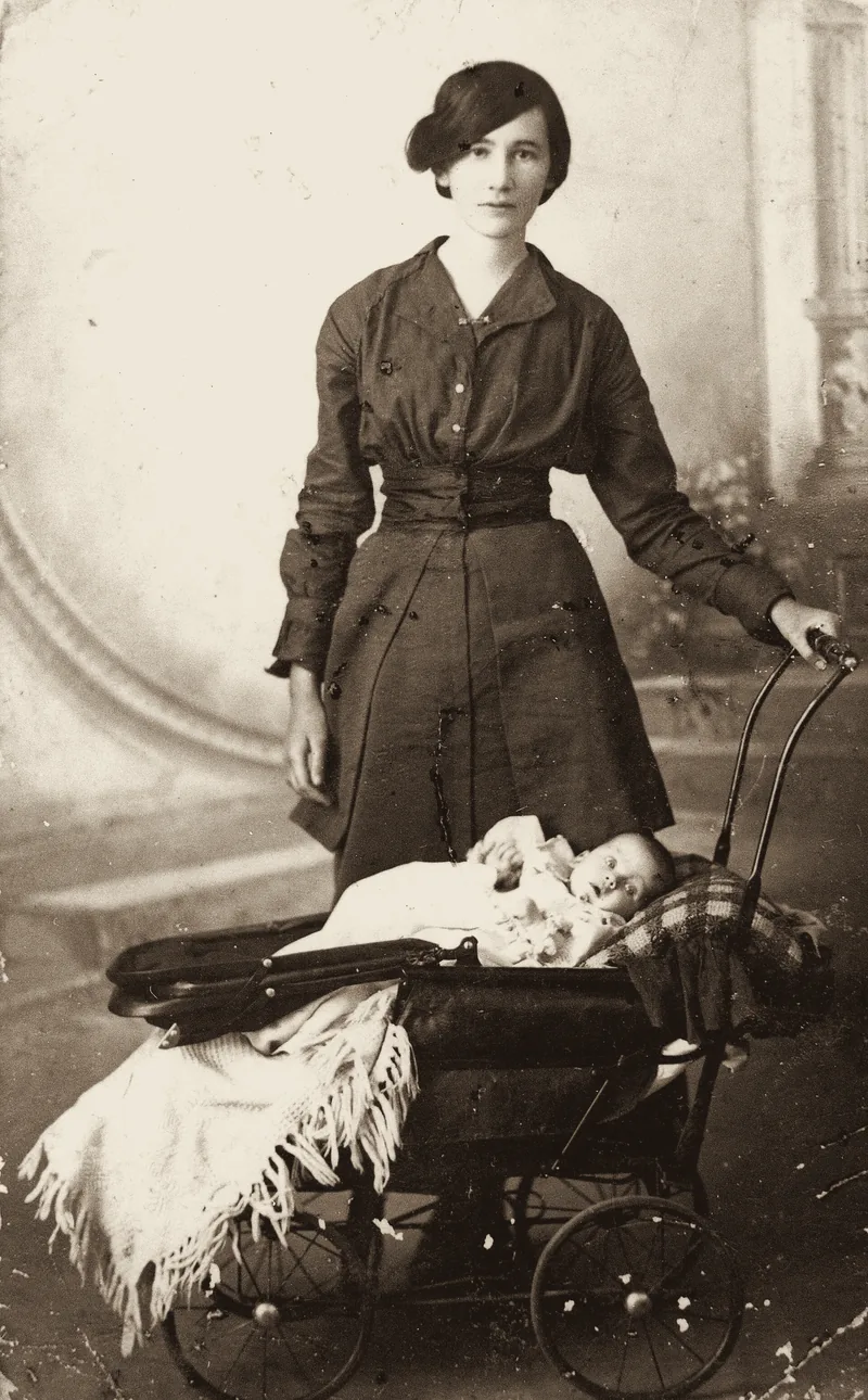 Studio portrait of a young woman with an infant in a pram, c. 1915. An archive photograph.