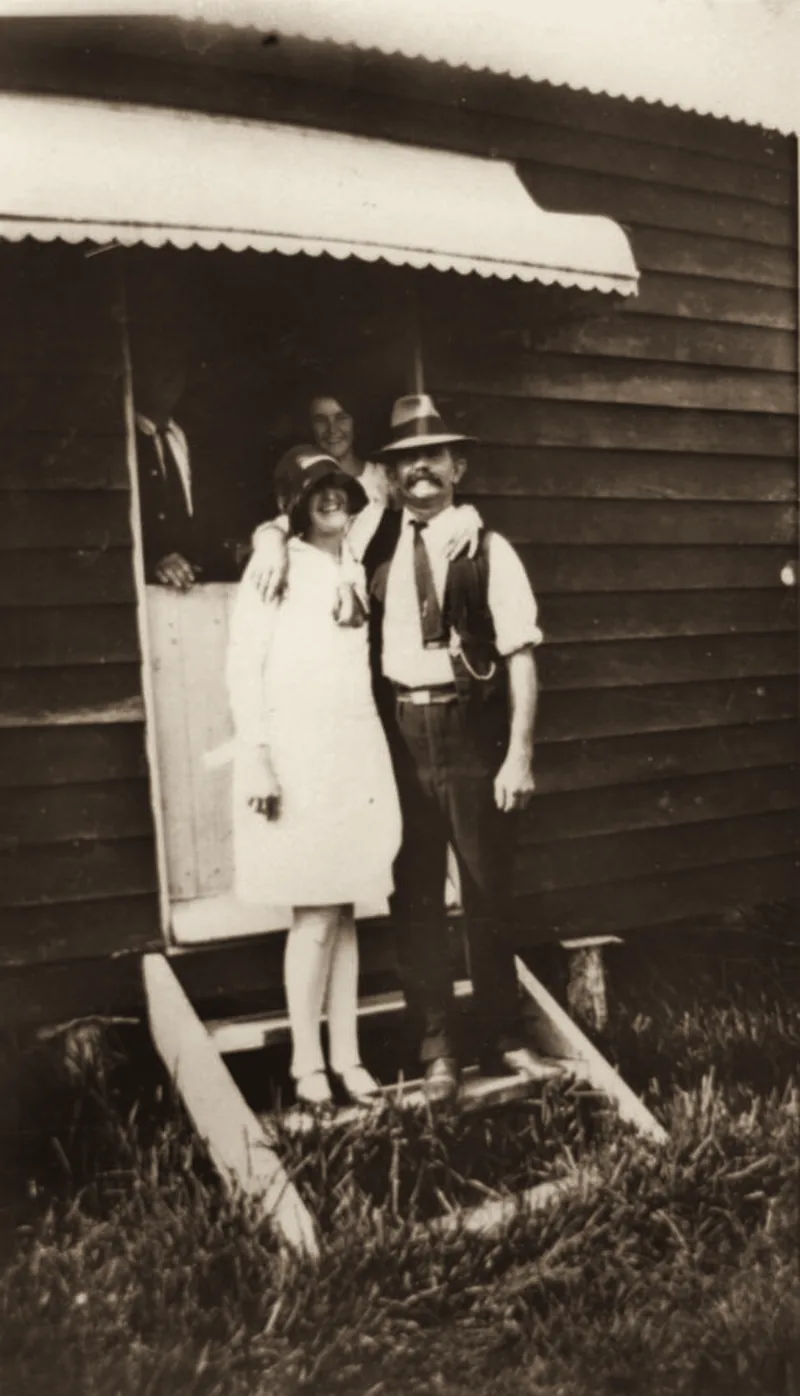 Man and woman on the steps of a holiday home at Cribb Island, 1928. An archive photograph.